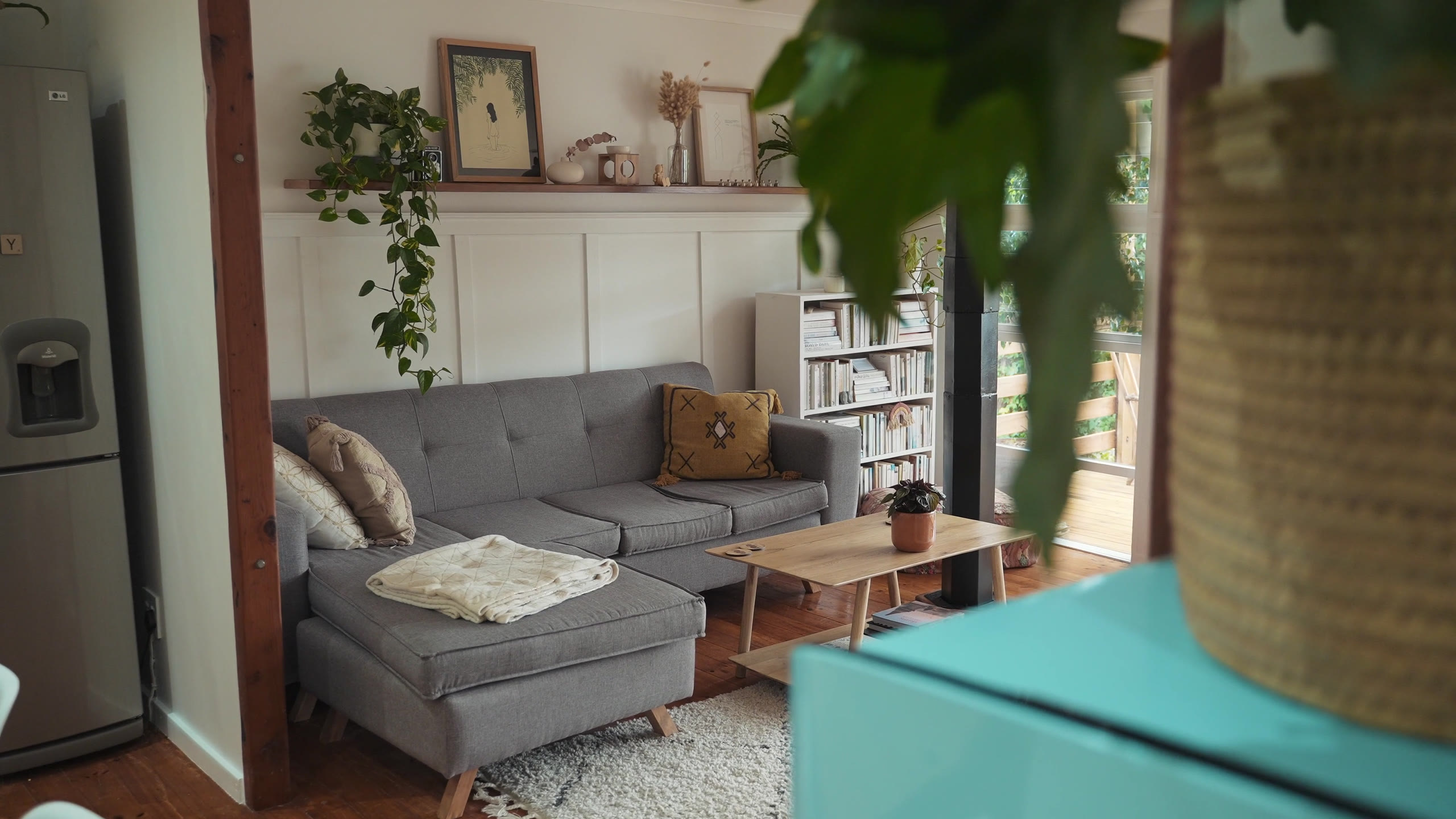 Bright living room in a short-term rental home, with plants and a glass door onto the garden